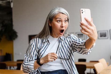 Shocked White Haired Mature Woman Taking Selfie Photo On Cellphone