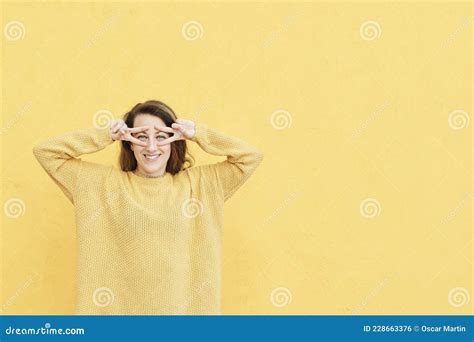 Portrait Of Funny Teenage Girl Making V Signs Or Peace Sign Near Her Face Isolated On Yellow