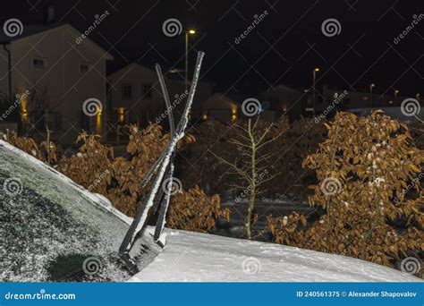 View Of Frozen Car With Raised Windshield Wipers On Frosty Winter Night
