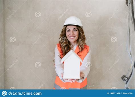 professional confident architect woman in construction site holding house model home renovation