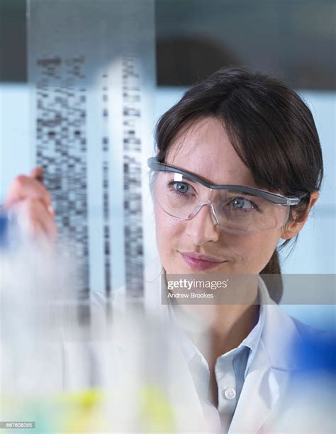 Researcher Holding A Dna Gel During A Genetic Experiment In A