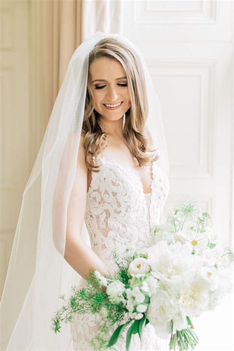 The Bride Is Holding Her Bouquet And Smiling