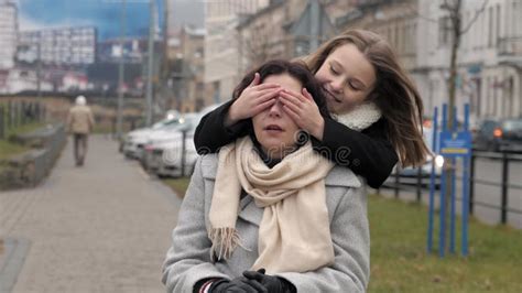 schoolgirl approaching to her handicapped mother on the pavement in a city stock footage video