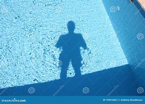 The Shadow Of A Man In A Swimming Pool In Bright Sunlight Stock Image