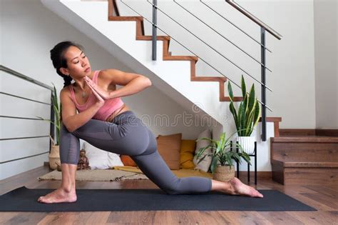 Young Asian Woman Doing Low Lunge Twist Yoga Pose At Home Parivrtta