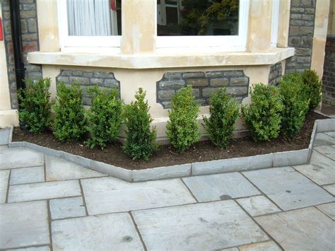 Paved Front Garden Bordered By Hedges Providing Minimal Maintenance