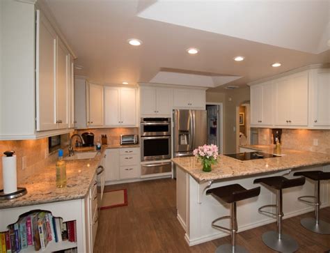 Deciding on warm or cool tones in your color palette is an essential first step. StarMark ivory cream cabinets with Cambria Bradshaw, wood ...