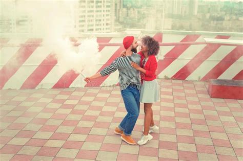 Cute Loving Couple Dancing In White Smoke On The Roof And Smiling Stock
