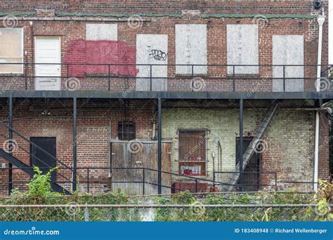Back Of A Boarded Up Abandoned Red Brick Apartment Building Stock Photo