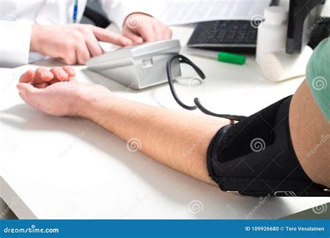 Doctor Or Nurse Measure Blood Pressure Of A Patient Stock Photo