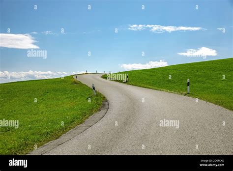 Country Road In A Green Hilly Landscape Stock Photo Alamy