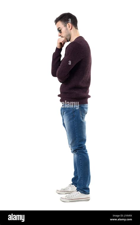 Side View Of Sad Worried Man In Maroon Pullover Looking Down Full Body