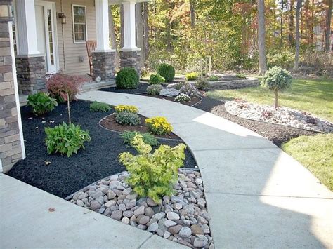 The Contrast Of Black Mulch And Stone Front Yard Landscaping