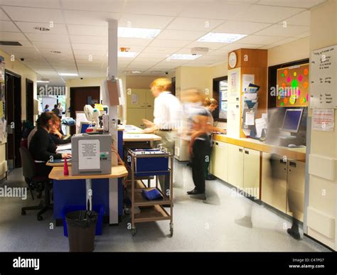 Busy Uk Nhs Hospital Ward With Doctors And Nurses Rushing About Blurred Showing Movement And