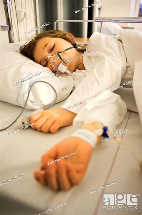 Girl Lying On Hospital Bed With Oxygen Mask Over Face Stock Photo