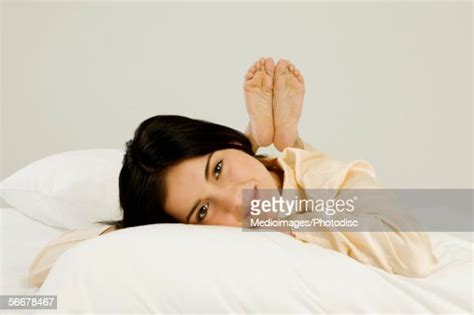 Portrait Of A Young Woman Lying On A Bed Photo Getty Images