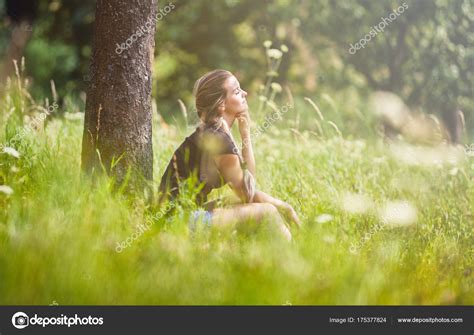 Photo Girl Sitting Under Tree Relaxed Girl Sitting Under Tree On Meadow At Summer Day — Stock