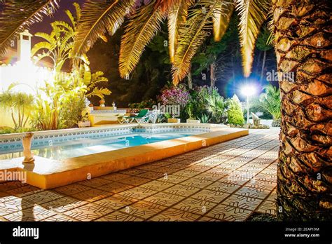 Swimming Pool At Night Set In A Mature Garden At A Classic Spanish Villa In Moraira Spain Stock