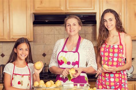 Happy Smiling Mother And Her Daughters Cooking Dinner Stock Image