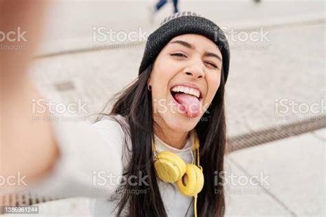 Latina Taking A Selfie With Her Smart Phone Sticking Out Her Tongue And