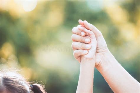 Mother And Little Child Girl Holding Hands Raised Together Stock Photo