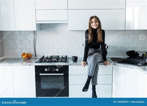 Attractive Woman Sitting On Kitchen Counter Young Housewife Relaxing