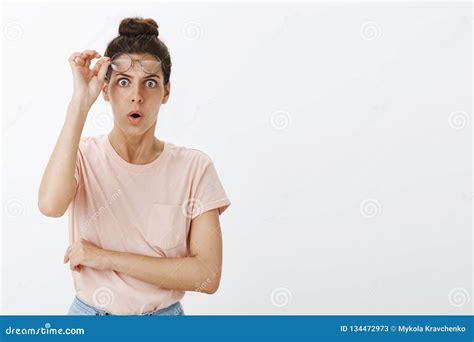 portrait of stunned and shocked woman in stupor taking off glasses and dropping jaw as looking