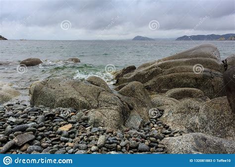 Beautiful Sea Bay With A Rocky Shore And Clouds Like Stones In Stock