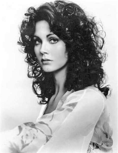 black and white photograph of a woman with curly hair wearing a blouse over her shoulder