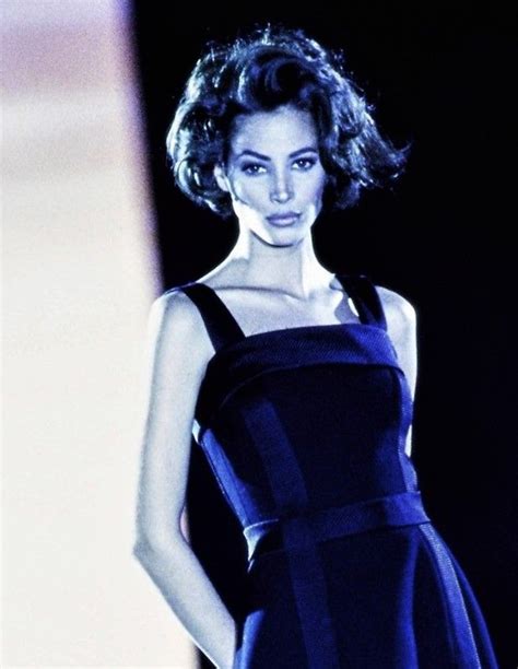A Woman In A Black And Blue Dress On A Runway