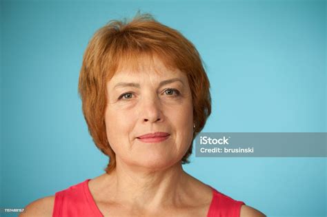 Studio Portrait Of An Attractive 60 Year Old Woman On A Blue Background