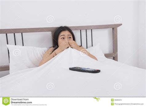 Frightened Woman Watching Tv In Bed Stock Photography Image 35905372