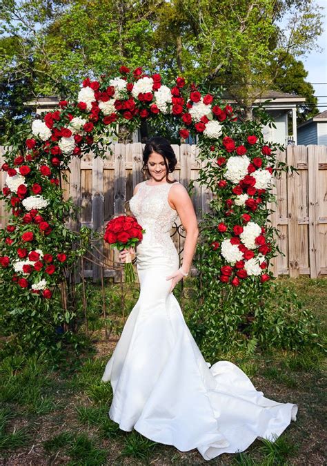 Bride In Front Of The Red Rose Wedding Arch At The Rails On Wright