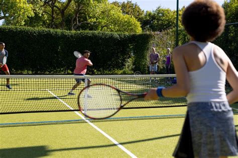 Happy Diverse Group Of Friends Playing Tennis At Tennis Court Stock
