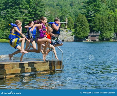 Kids Having Summer Fun Jumping Off Dock Into Lake Stock Photo Image