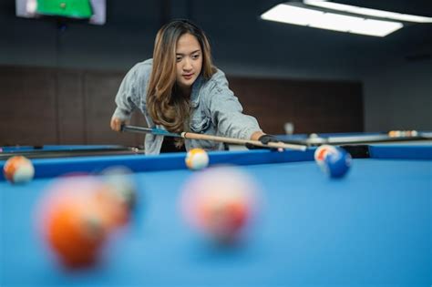 premium photo beautiful asian woman poking the biliiard ball using the cue stick at billiard
