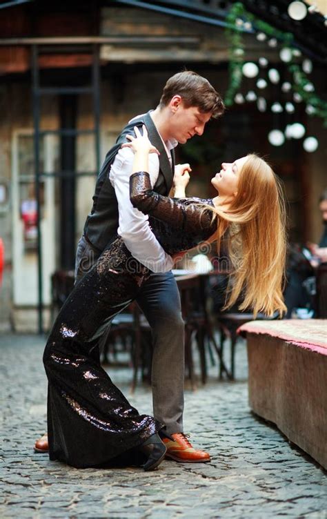 Joyful Young Couple In Love Dancing Latin On Evening Street Near The Cafe Of Old Town Stock