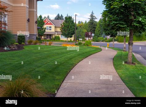House Frontyard And Parking Strip Freshly Mowed Green Grass Lawn In