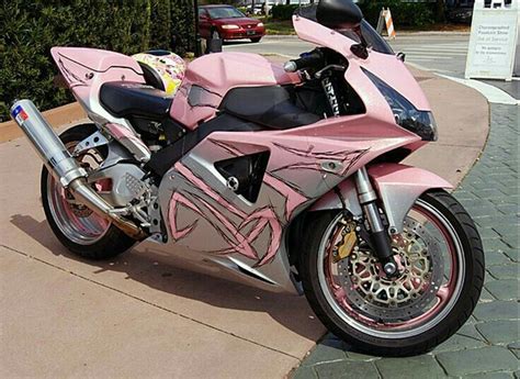 A Pink Motorcycle Is Parked On The Sidewalk