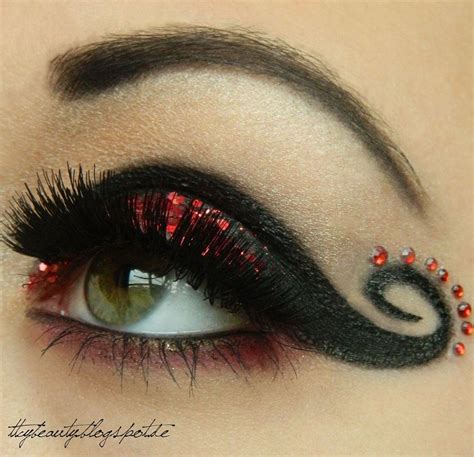 Dramatic Black Swirled Eye Makeup With Red Glitter And Crystal Accents