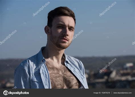 Guy Posing In Unbutton Shirt With Hairy Naked Torso Stock Photo