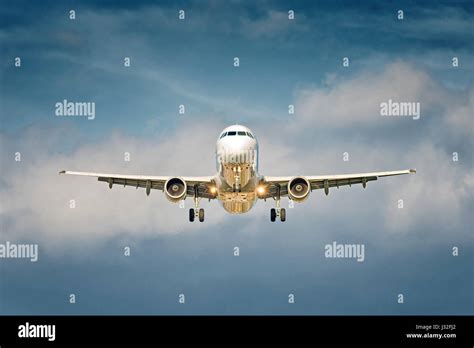 Front View Of A Big Jet Plane Taking Off On Blue Cloudy Sky Background