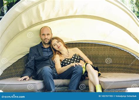 Portrait Of Happy Woman Leaning Head On Man`s Shoulder At Rottan Sofa In Restoutant Stock Image
