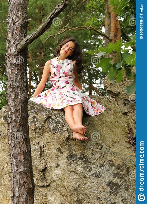 Smiling Teenage Girl Sitting On Rock In Forest Stock Image - Image of barefooted, concept: 200632959