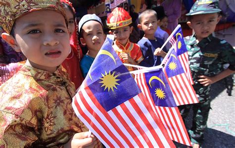 Tanpa sebarang petunjuk yang kukuh, kes. Children in national attires with Malaysian flags in their ...