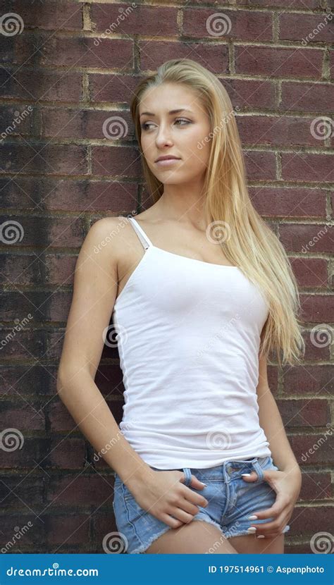 Beautiful Blonde Woman In White Tanktop And Denim Shorts Stock Image