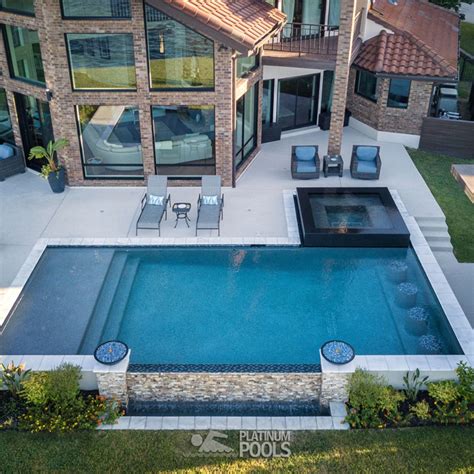 An Aerial View Of A House With A Swimming Pool And Patio Furniture In