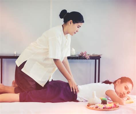 Female Masseur Giving Asian Female A Thai Back Massage In Thai Relaxing Spa Therapy Stock Image