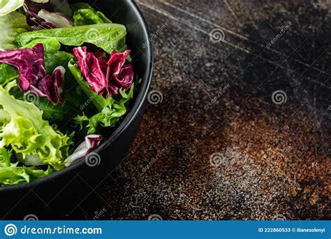 Fresh Leaves Of Different Lettuce Salad On Old Dark Rustic Background