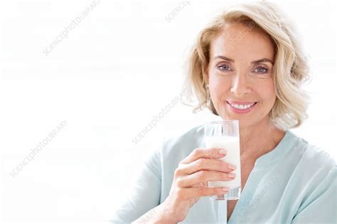 mature woman smiling with drink stock image f020 7461 science photo library